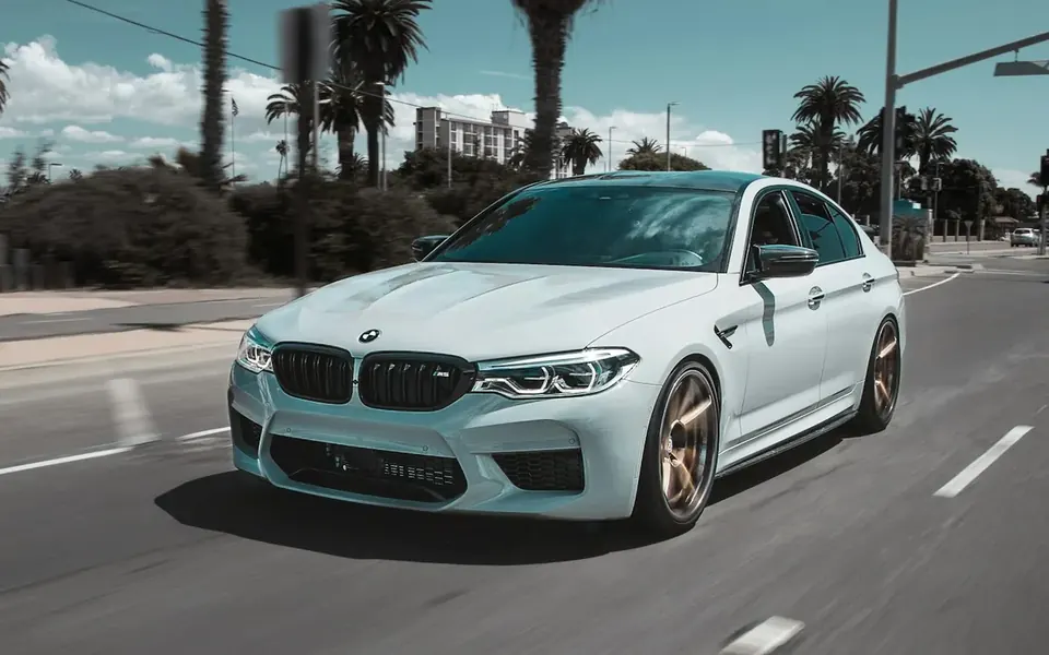White BMW sedan on a sunny South OC–style street — European repair help near Mission Viejo